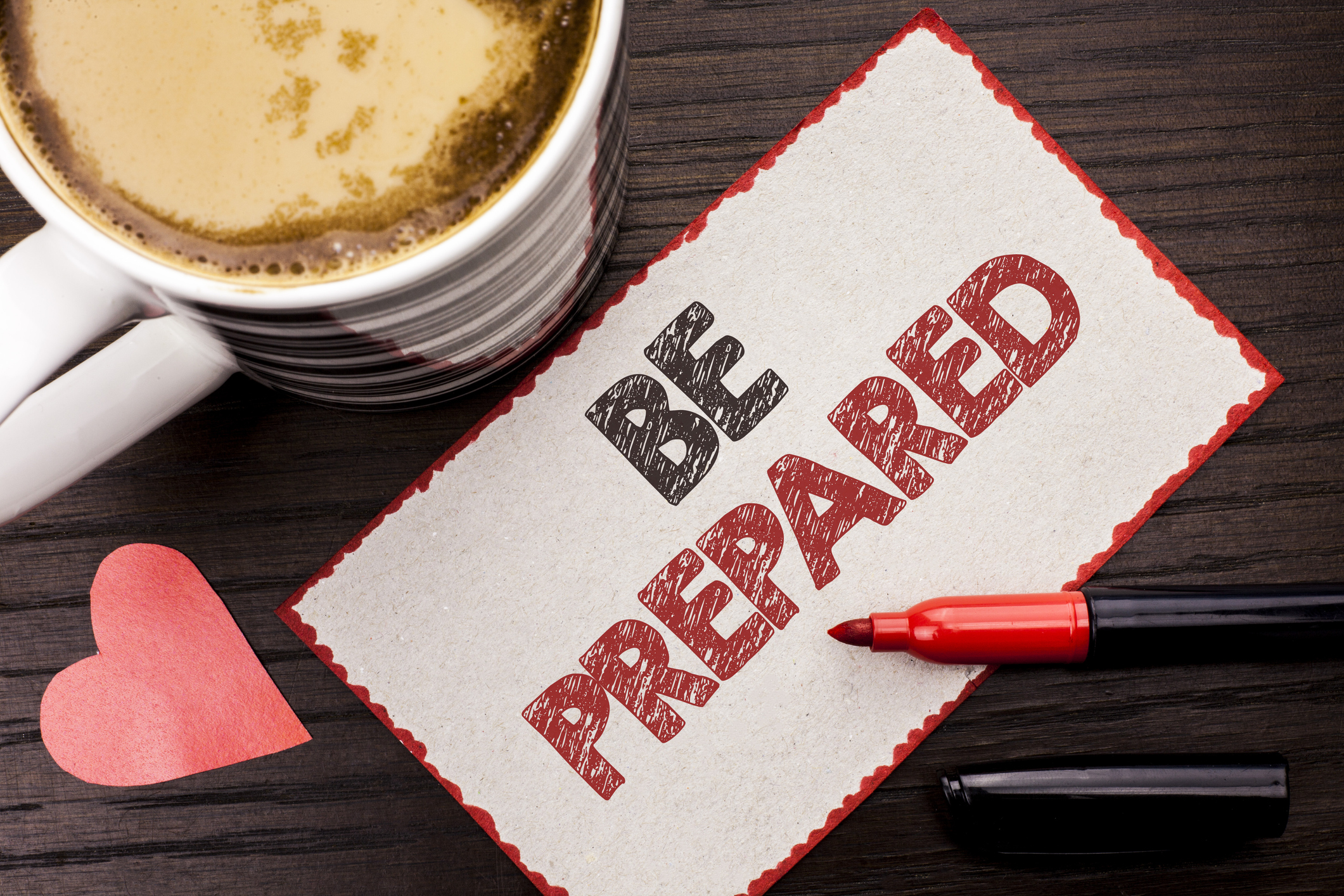 Text sign showing Be Prepared. Conceptual photo Preparedness Challenge Opportunity Prepare Plan Management written on Sticky Note on the wooden background Coffee Cup Heart Marker next to it.